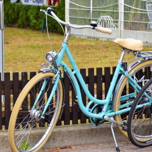 Mint-green step-through city bike with a front lamp, mudguards and cream-wall tyres